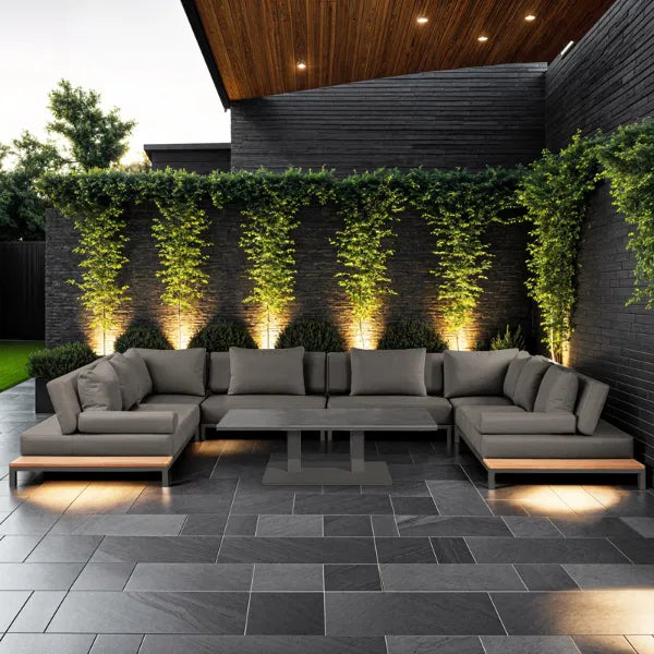 U-shape grey outdoor sofa with coffee table. grey patio and brick walls surround with lighting